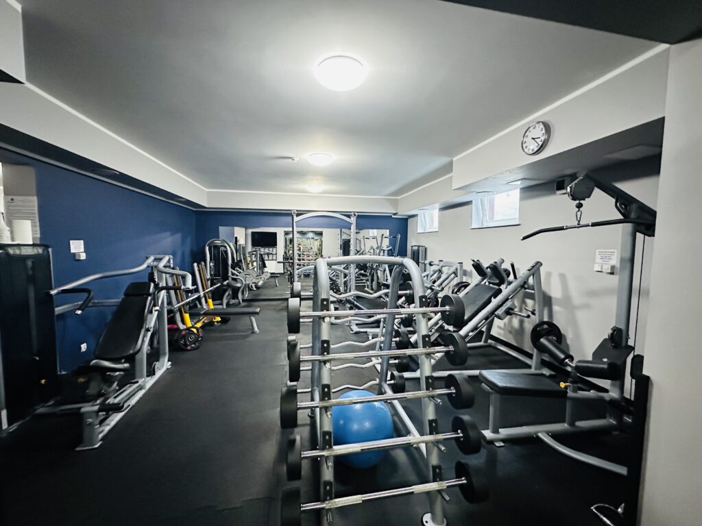 Na zdjęciu przedstawione jest wnętrze sali ćwiczeń razem ze sprzętem do ćwiczenia.